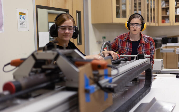 Scientists splitting a sediment core with the GeoTek core splitter