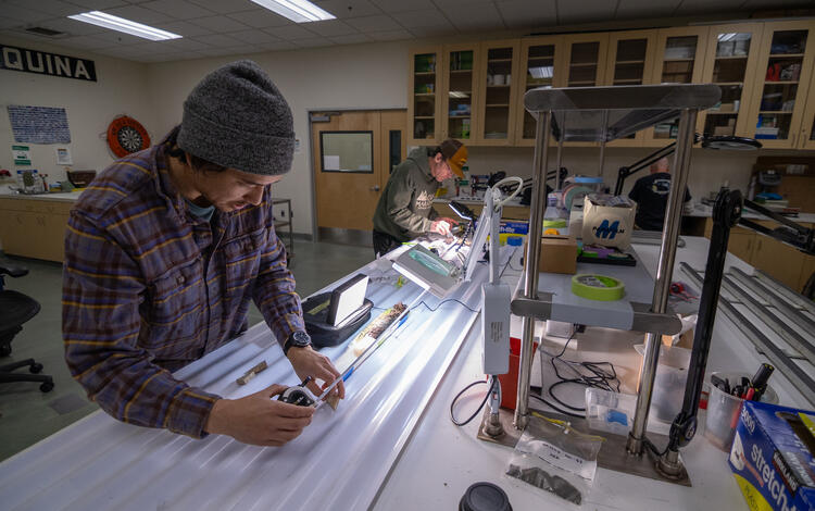 Scientists sub-sampling split sediment cores
