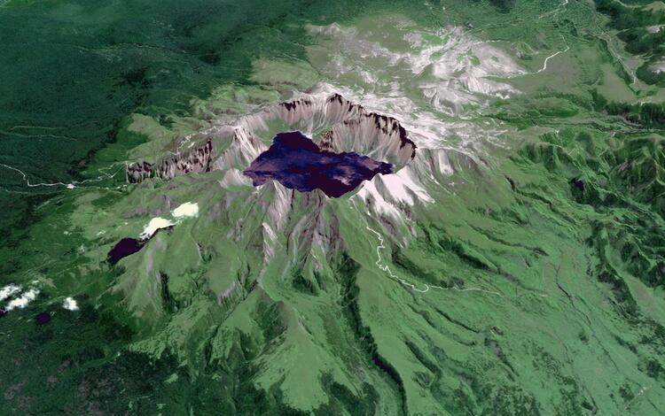 Satellite image of a volcano crater filled with a lake and green vegetation down much of the sides