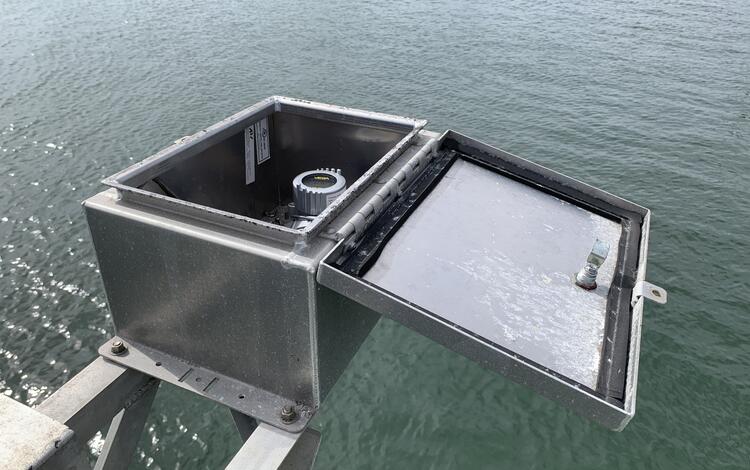 Looking into an open steel box suspended over the bay to see the radar electronics inside