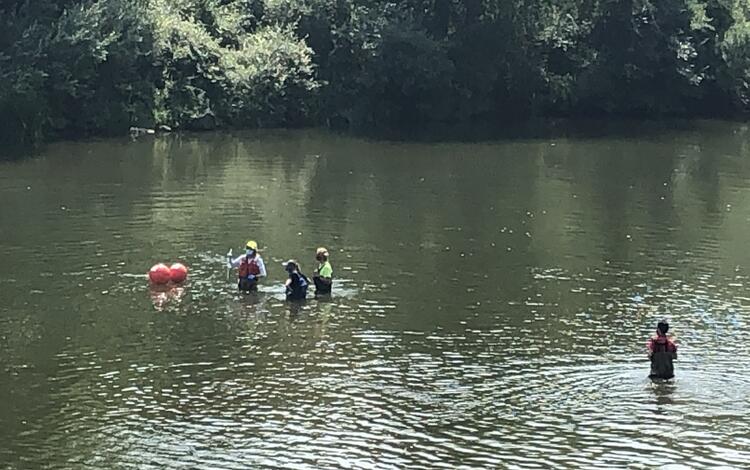 Scientists checking a monitor downstream of reservoir