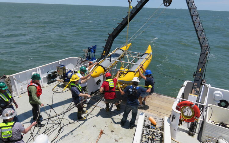 USGS staff get ready to deploy the chirp 512i sub-bottom profiling system from the stern of a research vessel.