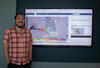 Hydrologic Technician, Lawrence Fujiwara, stands next to display showing Bay-Delta real time electrical conductivity conditions.