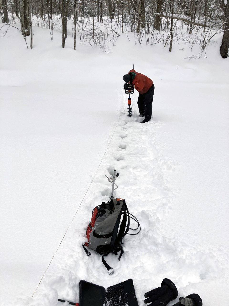 Hydrologic technician drills holes for a measurement